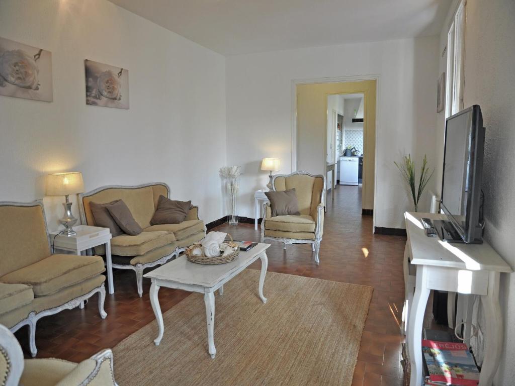 un salon avec un canapé, une table et une télévision dans l'établissement Villa in Fréjus with Pool near Beach, cleaning included, à Fréjus