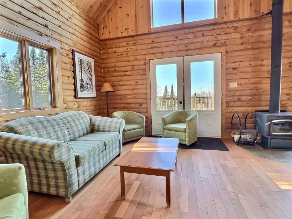 sala de estar con sofá, sillas y fogones en Domaine Appalaches 20 Incredible view and spa, en Saint-Paul-de-Montminy