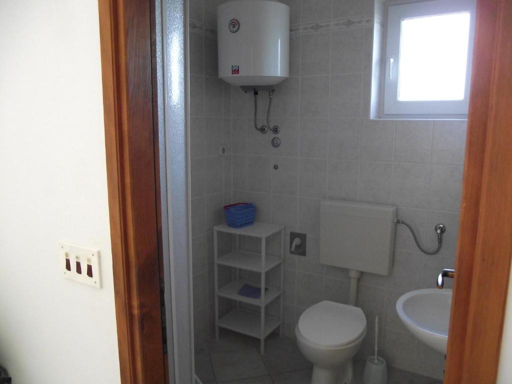 a small bathroom with a toilet and a sink at Apartments Irena in Božava