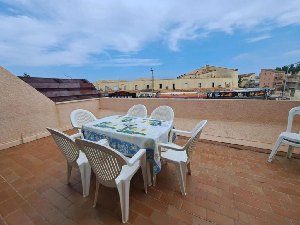 une table et des chaises assises sur un toit dans l'établissement Appartement 2 pièces en duplex, proche plage, parking privé - FR-1-326-861, à Marseillan