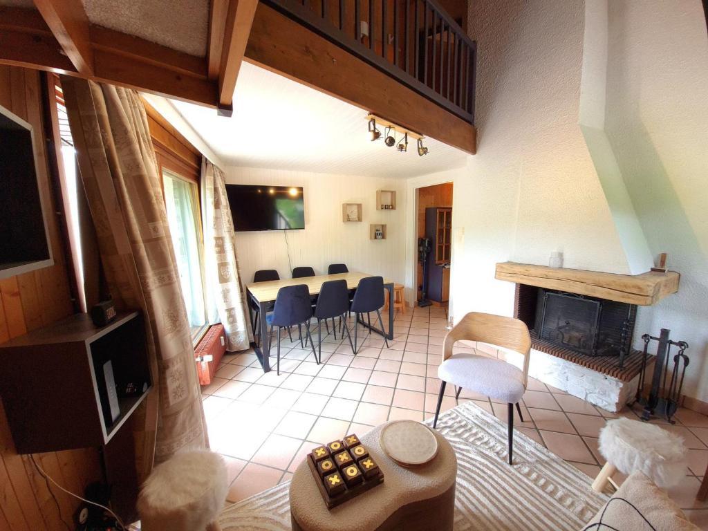 - un salon avec une cheminée, une table et des chaises dans l'établissement Appartement T3 à La Clusaz, proche pistes, parking et Wi-Fi, pour 6 personnes - FR-1-459-246, à La Clusaz
