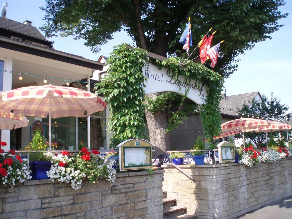 ein Restaurant mit Blumen und Pflanzen an einer Ziegelmauer in der Unterkunft Lindenhof in Osterspai