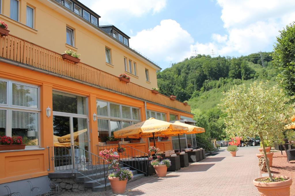 un edificio naranja con sombrillas fuera de él en BSW Ferienhotel Lindenbach, en Bad Ems