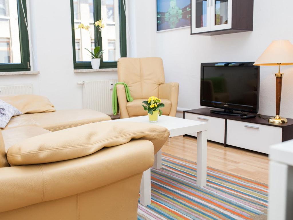 ein Wohnzimmer mit einem Sofa und einem TV in der Unterkunft Ferienwohnung Leipzig Ost in Leipzig