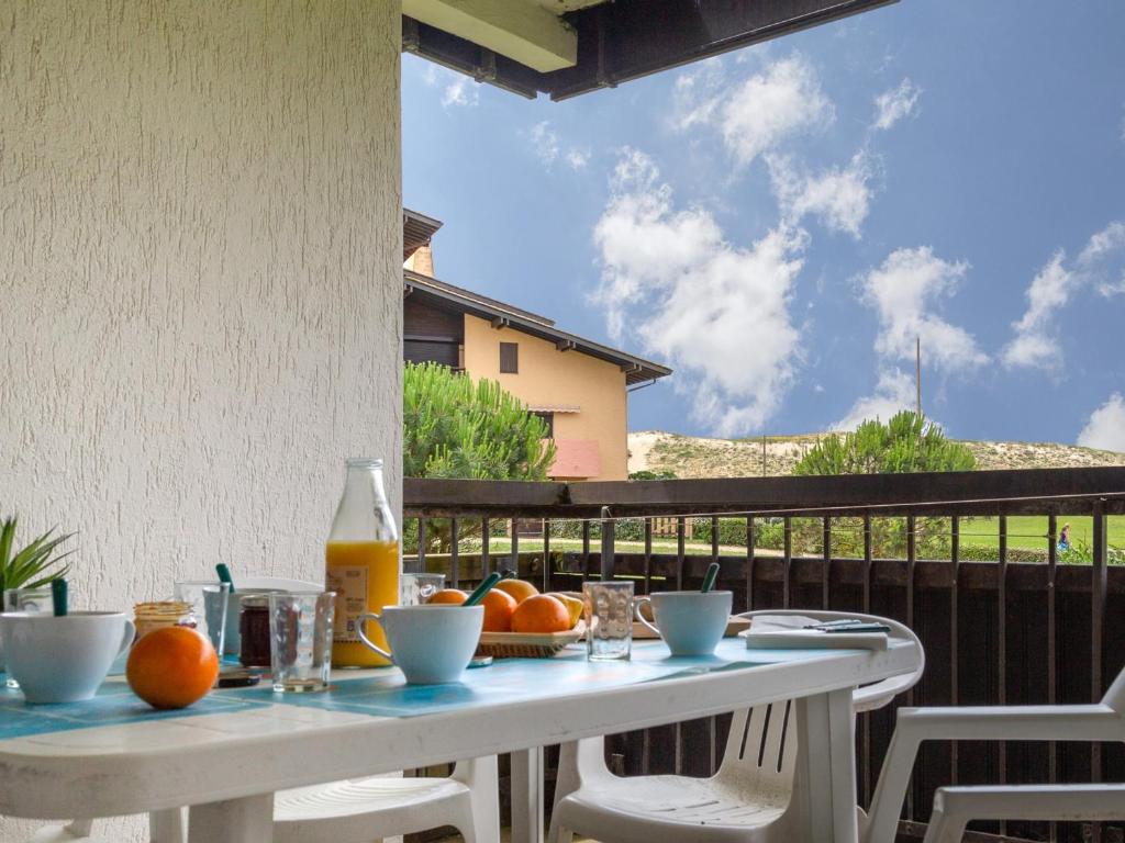 - une table avec des oranges et des jus sur un balcon dans l'établissement Appartement Spacieux à Seignosse, Terrasse et Parking, à Proximité de la Plage - FR-1-239-401, à Seignosse