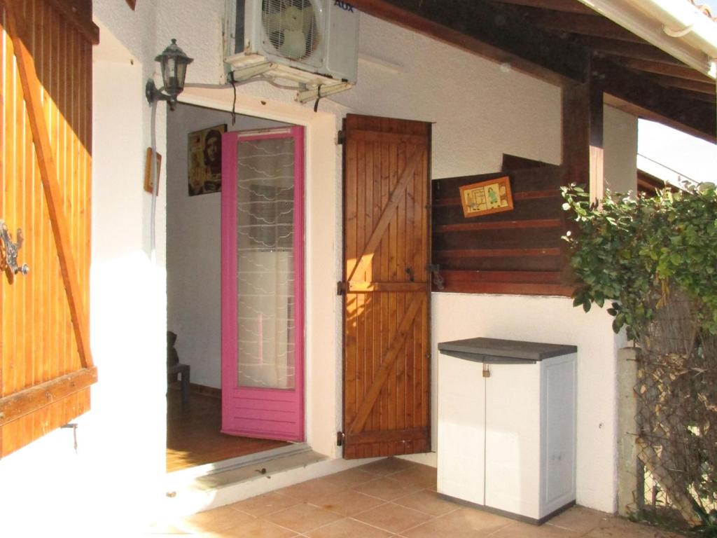une chambre avec une porte rose et une poubelle dans l'établissement Maison mitoyenne à 300m de la plage avec jardin et parking, 4 pers - FR-1-521-164, à Biscarrosse