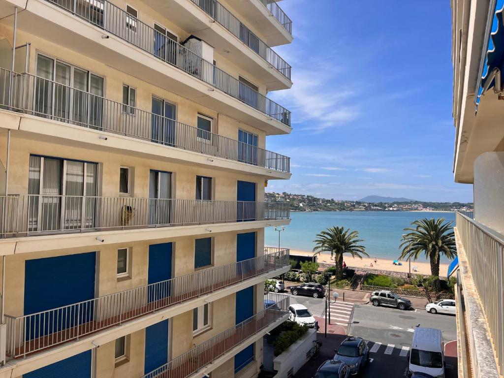 une vue de la plage depuis un immeuble dans l'établissement Appartement lumineux, proche plage, balcon, parking, WiFi - FR-1-239-962, à Saint-Jean-de-Luz
