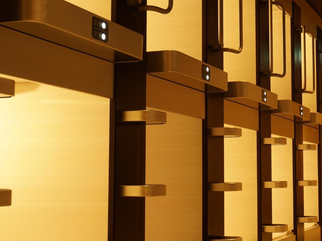 a row of metal doors with lights on them at Akihabara Bay Hotel (Female Only) in Tokyo