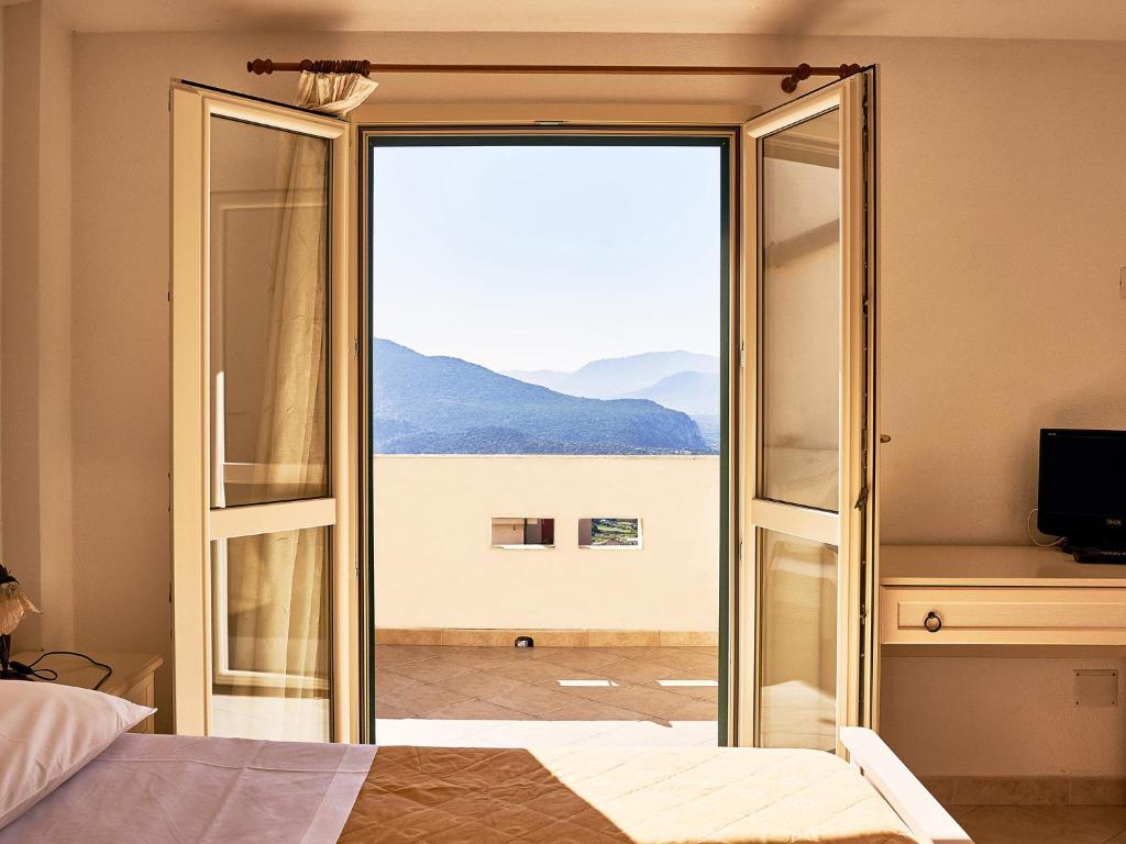 a bedroom with a sliding glass door with a view at Goritto in Dorgali