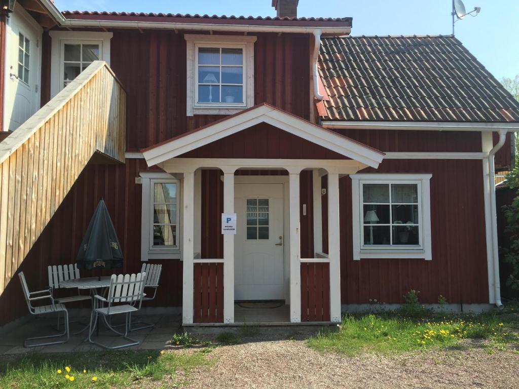 a red house with a table and chairs in front of it at Augustas Bed & Breakfast in Rättvik