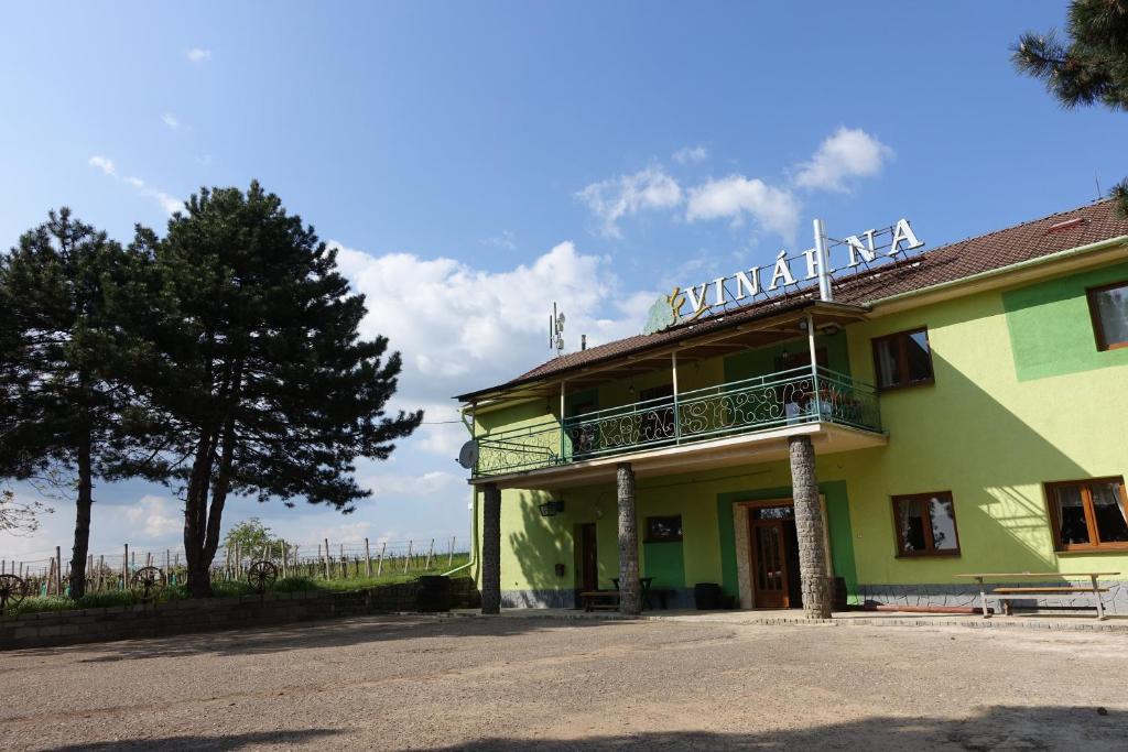 a yellow and green building with a balcony at Penzion u Tomčalů in Terezín