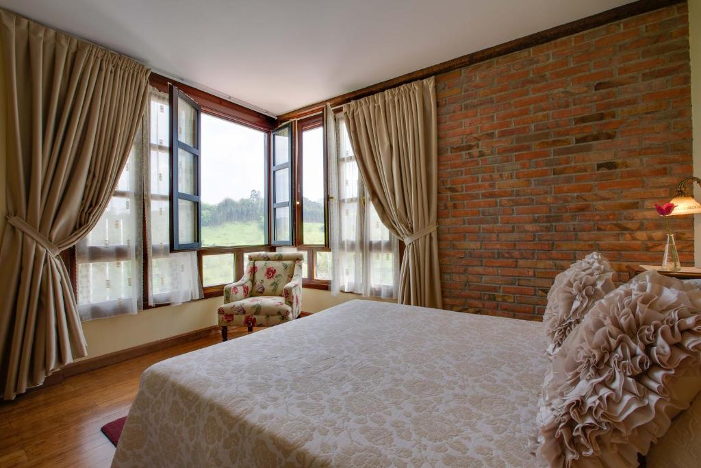 a bedroom with a bed and a brick wall at La Casona de la Roza in Valbucar