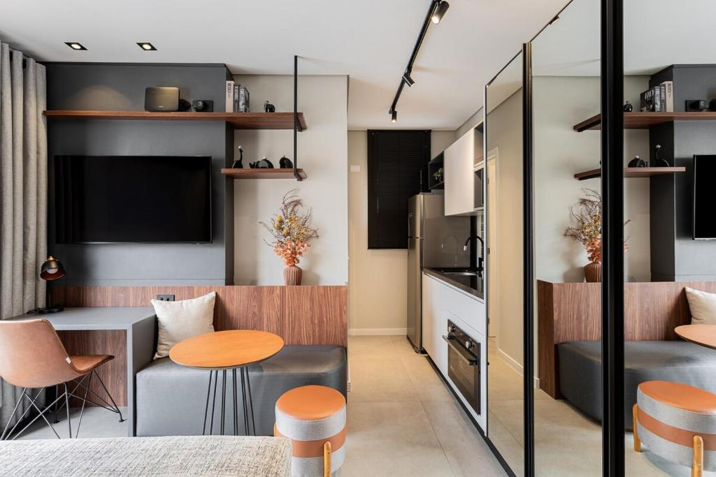 a living room with a table and a kitchen at Luxo e Conforto na Melhor Localização do Centro in Curitiba