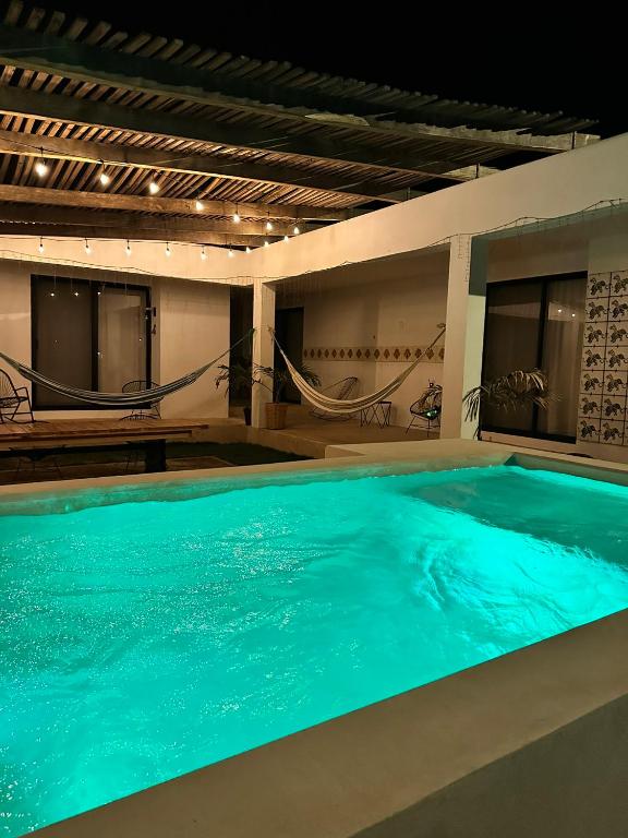 a large swimming pool with blue water in a building at Punta Conejo Camila bungalows Surf Camp in Reparo