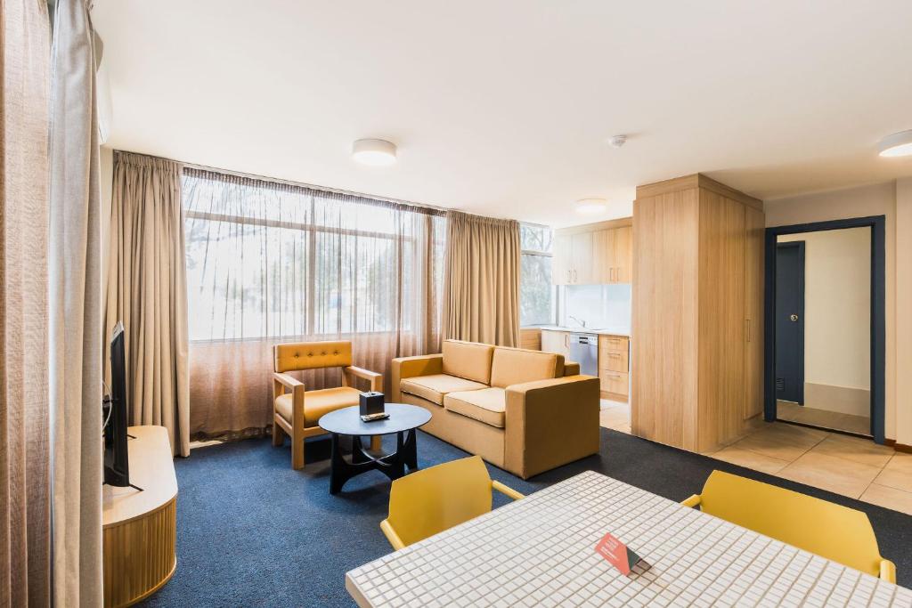 a living room with a couch and a table at Statesman Hotel in Canberra