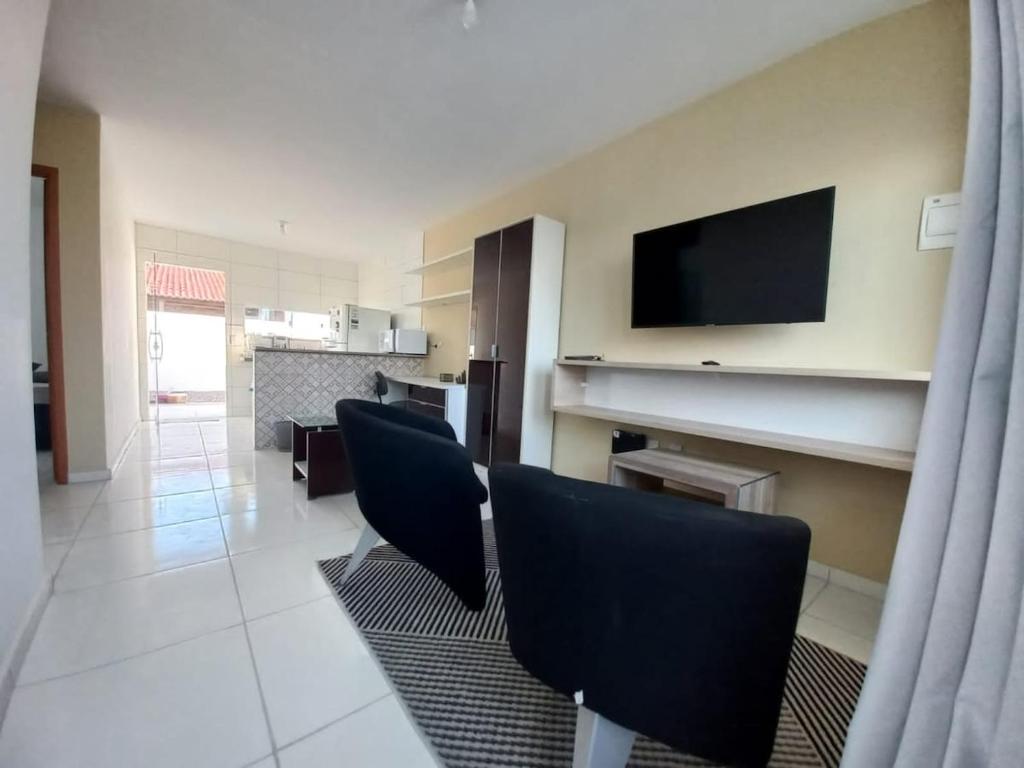 a living room with chairs and a flat screen tv at Casa 60 Completa Garagem 2ACs WIFI Juazeiro, Crato, Barbalha in Barbalha