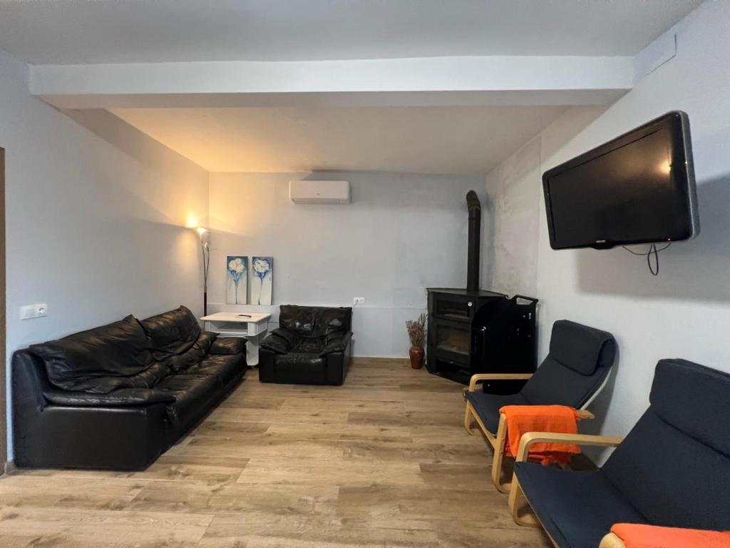 a living room with black leather furniture and a flat screen tv at Casa Chao in Estopiñán