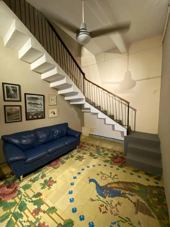a living room with a blue couch and a staircase at Mola Mola Rooms in Mérida