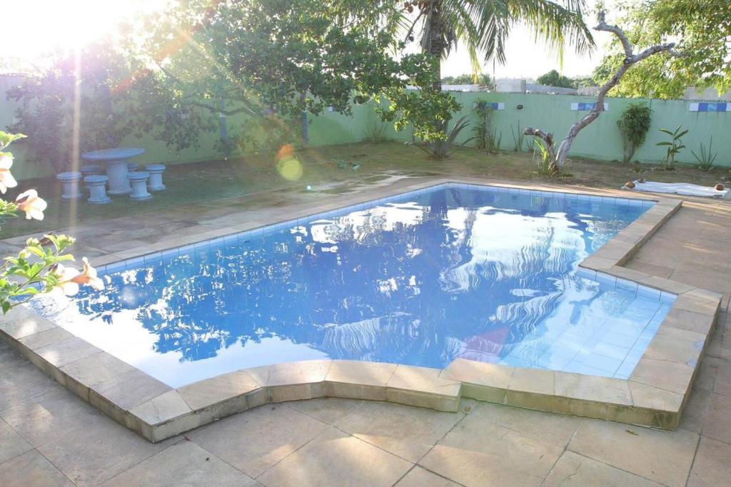 een zwembad met blauw water in een achtertuin bij Sítio em Barra de Jacuípe in Camaçari