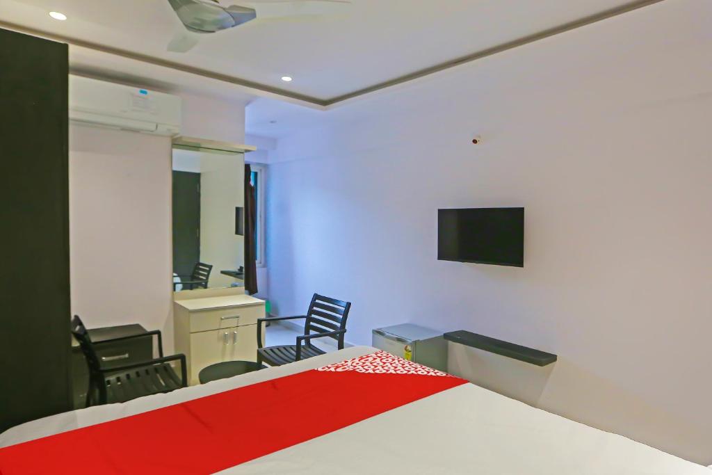 a bedroom with a bed and a desk and chairs at Super Hotel O Botcha Convection in Visakhapatnam