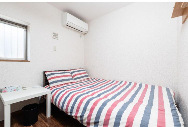 a small bedroom with a bed and a desk at 花迹民宿一号馆201 通天阁天王寺步行圈 心斋桥日本桥4分钟车程 in Osaka