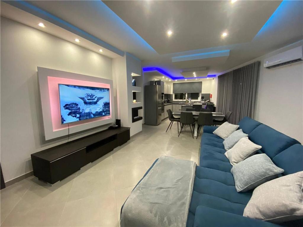 a living room with a blue couch and a tv at Luxury Apartment in Gzira close to Sliema 3 BR Apartment Sleep 8 in Il-Gżira