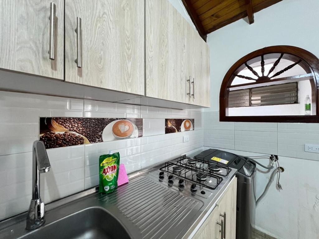 a kitchen with a sink and a stove and a window at CASA FAMILAR frente al parque in Buga