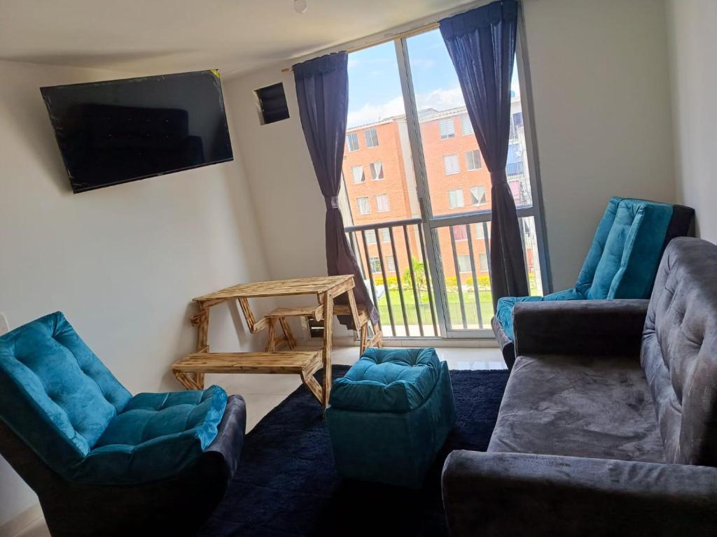 a living room with couches and a flat screen tv at Acogedor apartamento en ibague 403 in Ibagué