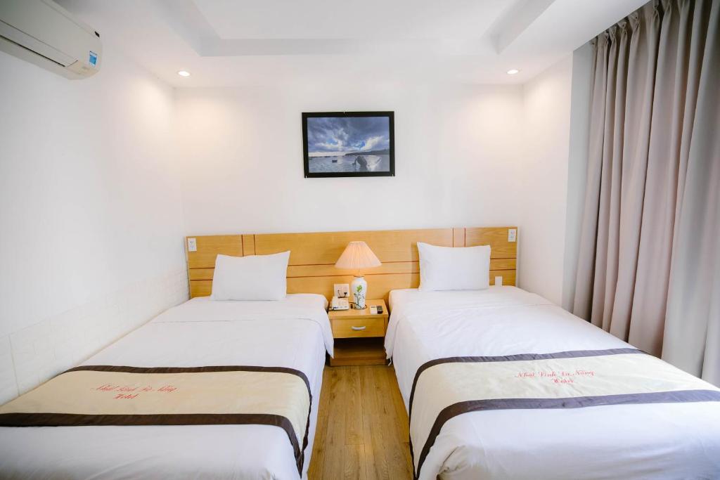 Postel nebo postele na pokoji v ubytování Nhat Linh Hotel & Suites Da Nang