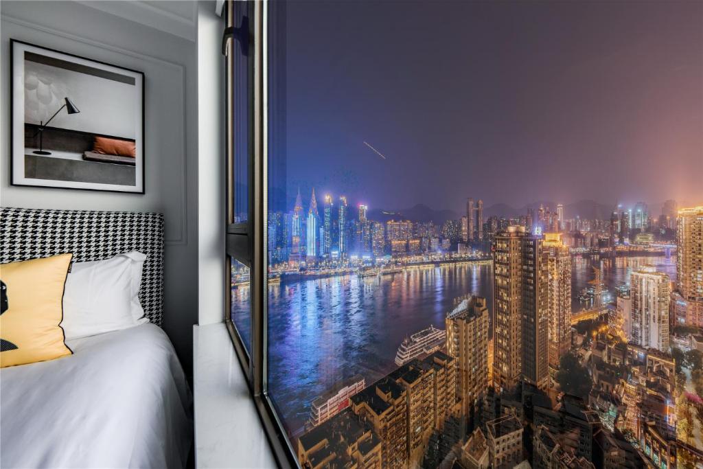 a bedroom with a view of a city at 云深处江景公寓 in Chongqing