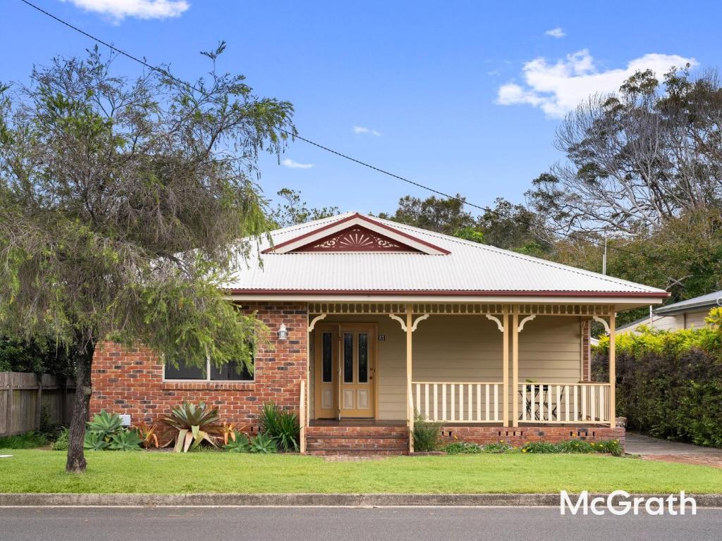 Mango Tree Cottage في ساوتيل: منزل من الطوب الأحمر أمامه شجرة