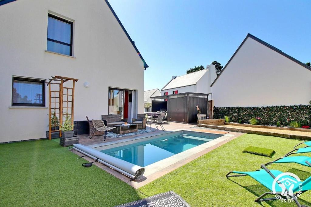 une cour arrière avec une piscine et une maison dans l'établissement Ti mod kozh, à Carnac