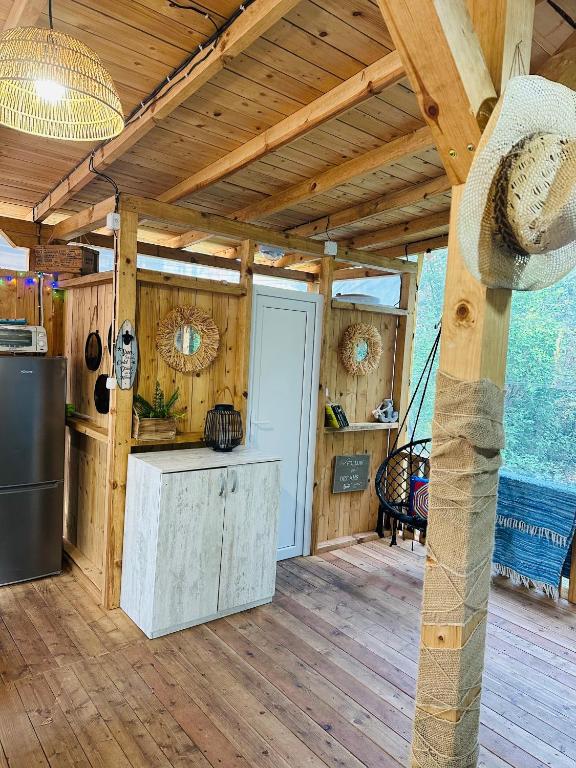 a kitchen in a cabin with a wooden ceiling at Каравана Синята Маймуна плаж Градина # RV Blue Monkey on the beach in Chernomorets
