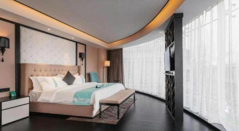 ein Schlafzimmer mit einem großen Bett und einem Fernseher in der Unterkunft Xana Hotelle Tianjin Binjiang Road Heping Road Metro Station Quanyechang in Tianjin