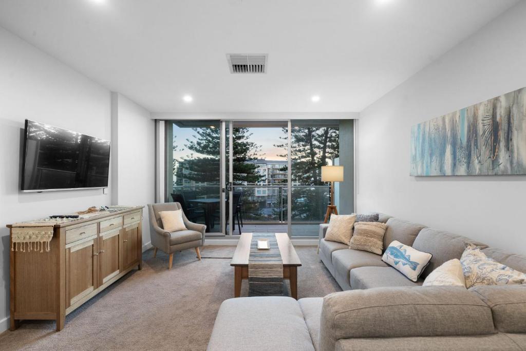una sala de estar con un sofá y una mesa en Belle Escapes - Coast on Colley Terrace, en Glenelg