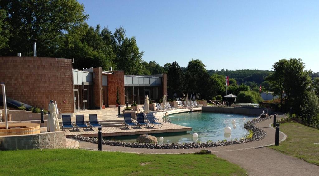 a swimming pool in front of a building at Ferienhaus Holunderweg an der Theme Obernsees mit Sauna in Truppach