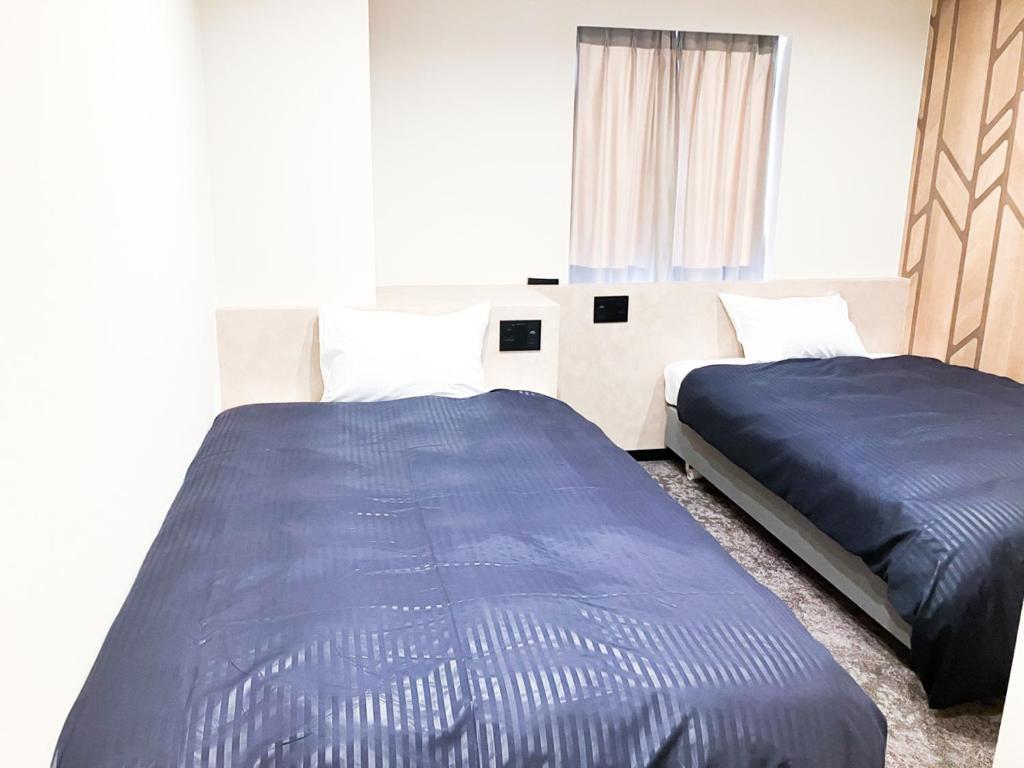 Postel nebo postele na pokoji v ubytování HOTEL LiVEMAX BUDGET Iyo Mishima