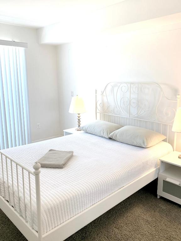 a bedroom with a white bed with white sheets and pillows at Western Melrose in Los Angeles