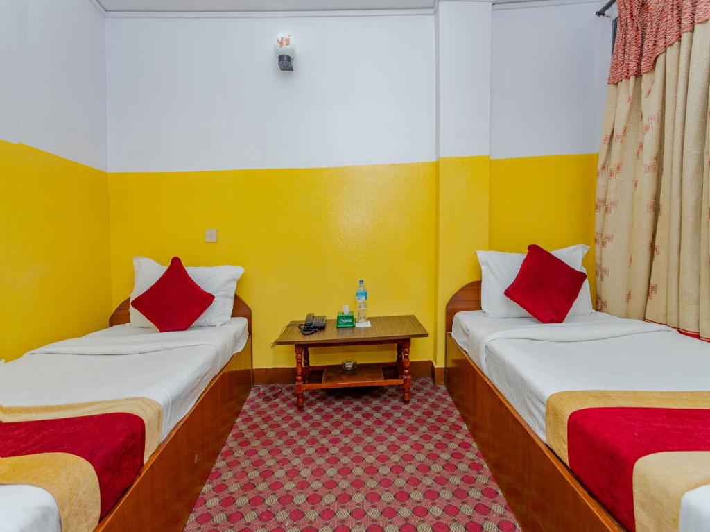 a small room with two beds and a table at Oyo 807 Hotel Grand Tokyo in Kathmandu