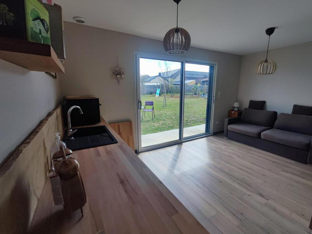 d'un salon avec une grande porte coulissante en verre. dans l'établissement un air de vacances, à Longué