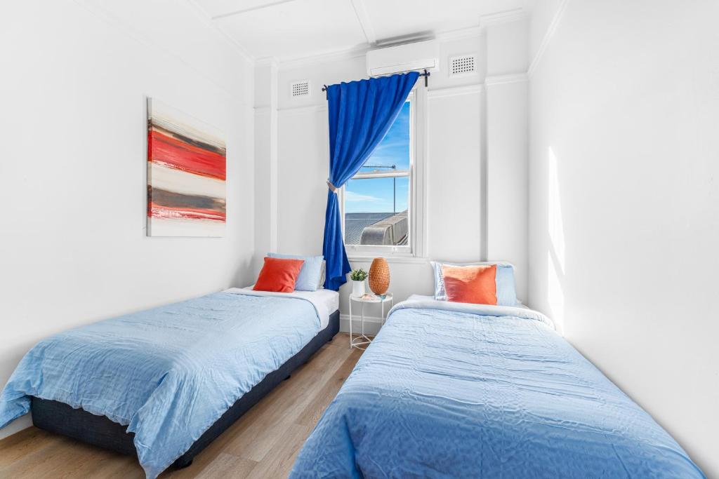 due letti in una stanza con finestra di Stay Today Hostel a Sydney