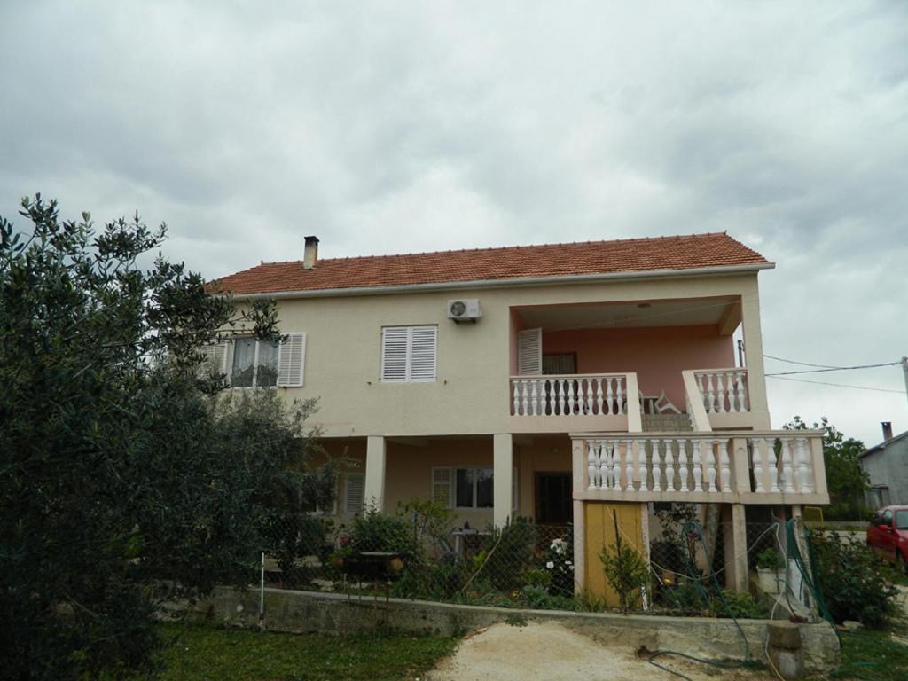 a house with a balcony on the front of it at Bartulovi dvori in Poljica
