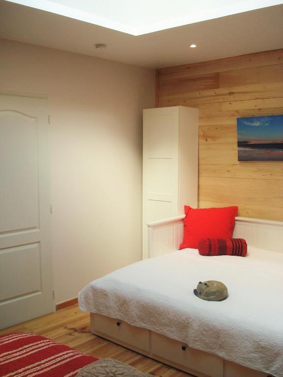 una camera con letto e cuscino rosso di Le Relais de la Praya a Lège-Cap-Ferret