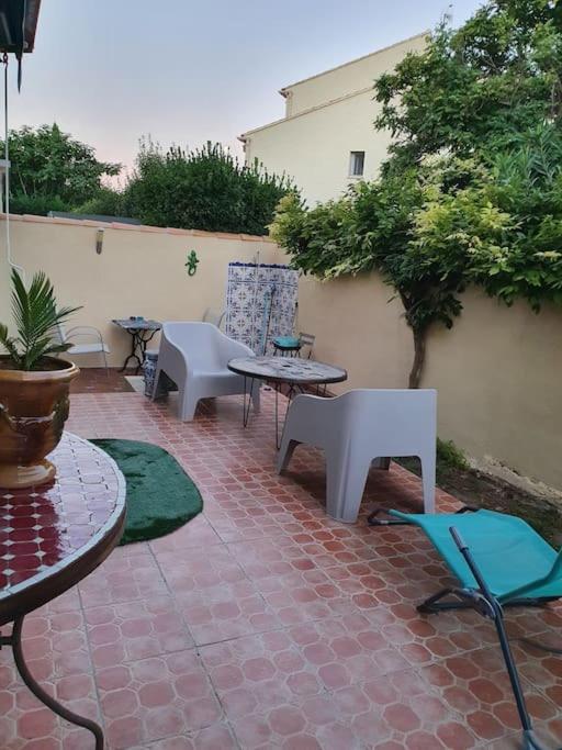 d'un patio en briques avec des tables et des chaises. dans l'établissement Studio Coraux, aux Lecques