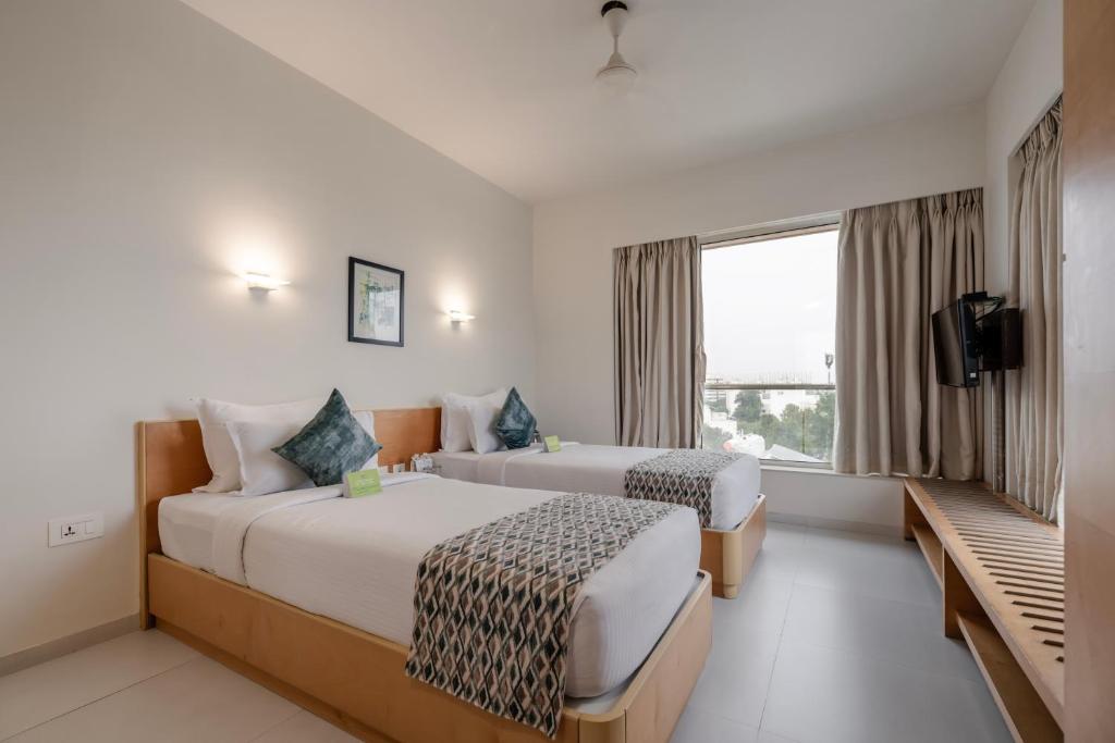 Postel nebo postele na pokoji v ubytování Quality Inn Patria Suites, Rajkot