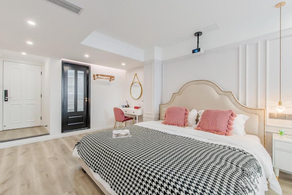 a white bedroom with a large bed with pink pillows at 云深处江景公寓 in Chongqing