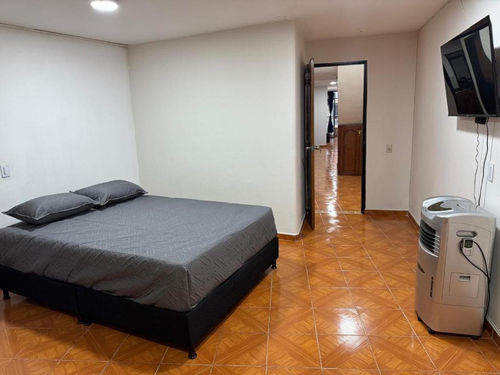 a bedroom with a bed and a flat screen tv at Casa del parque in Bello