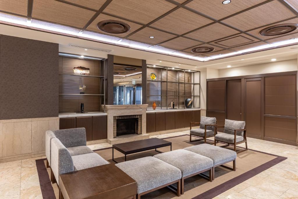a waiting room with chairs and a fireplace at HOTEL MYSTAYS Kanazawa Katamachi in Kanazawa