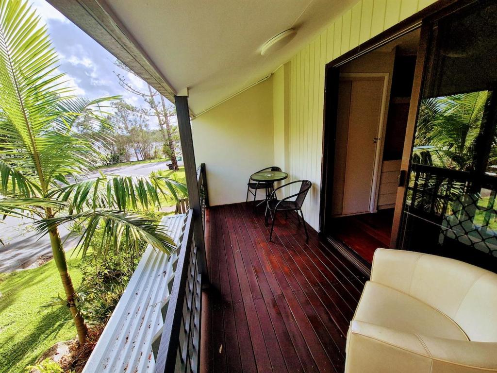 a balcony of a house with a chair and a table at River front views in Tewantin