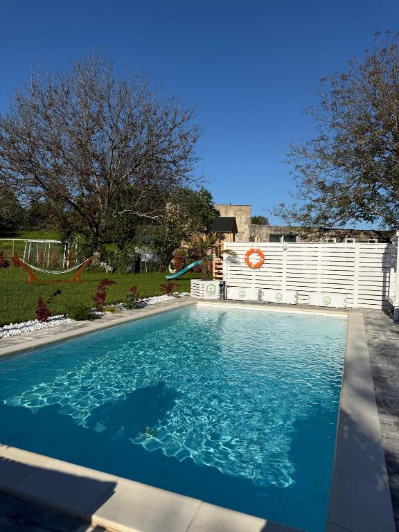 a swimming pool with blue water in a yard at La Căsuțe in Silvaşu de Jos